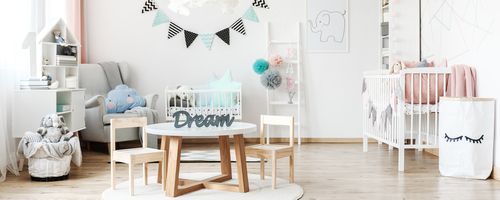 Image of a kids room with cradle and tables with pastel wall colour