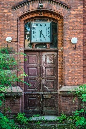 Classic bricks and iron door design for home with clock at the top