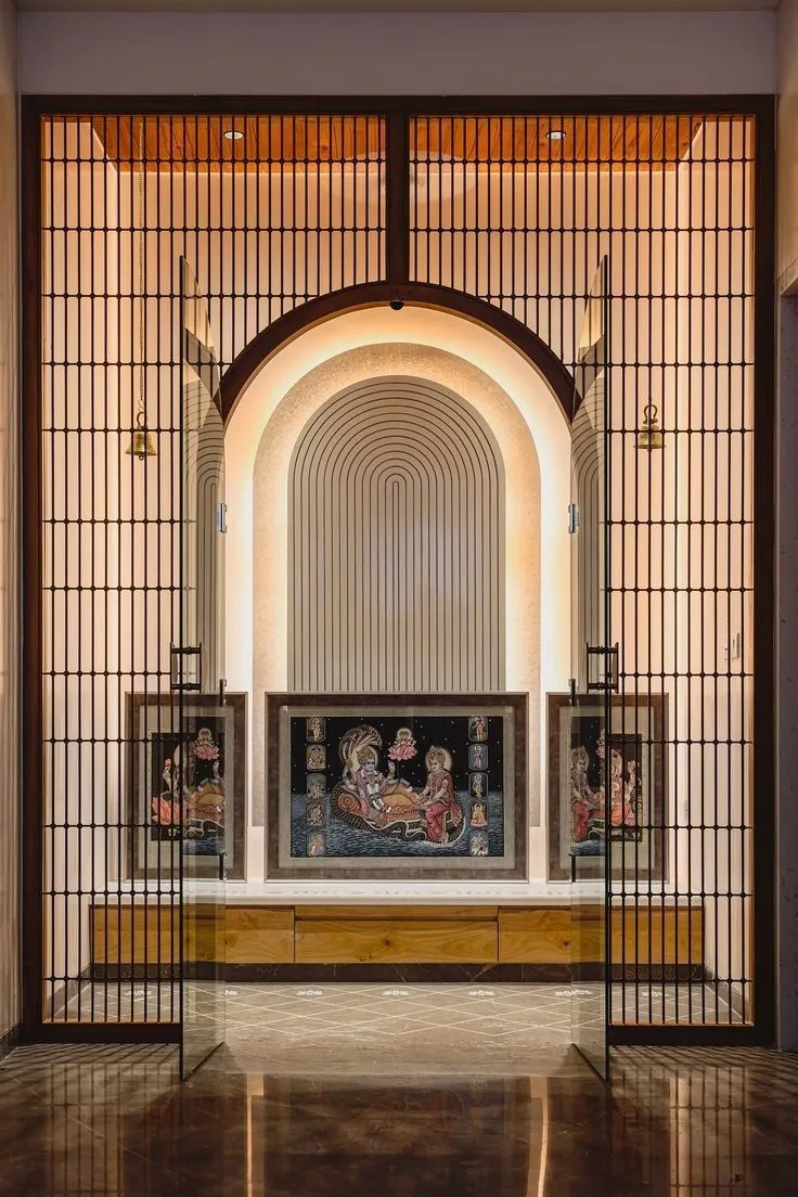 Unique style of arched pooja room with iron screen and photo frames of idols