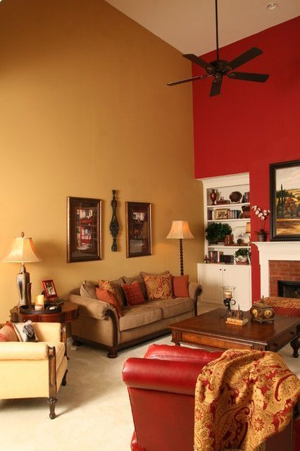 A living room with one mustard and one red wall