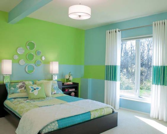 A bedroom with a geometric style light green colour with blue