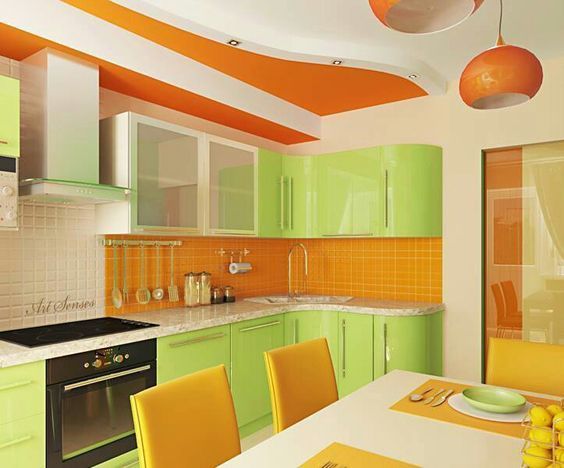 A kitchen and dinner space in light green colour combination with bright orange and white