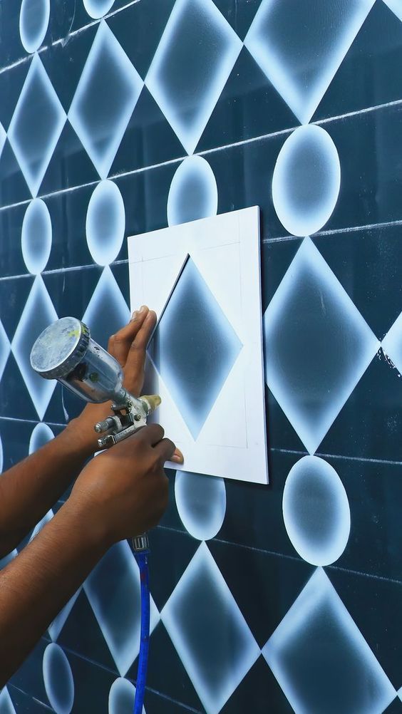 Geometric shapes being spray painted with spray paint machine