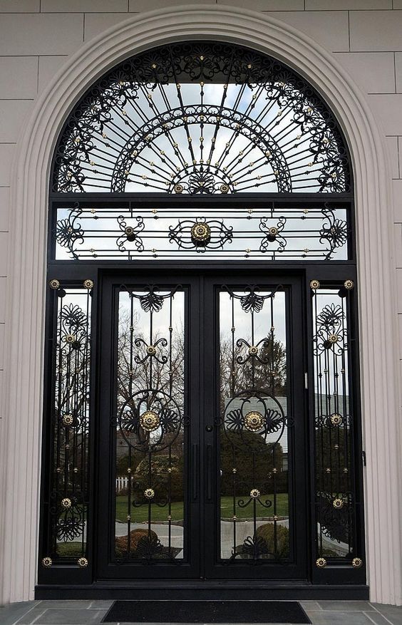 Arched sunburst modern gate design with ironwork and gold detailing