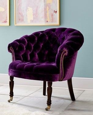 A purple velvet chair on white floor