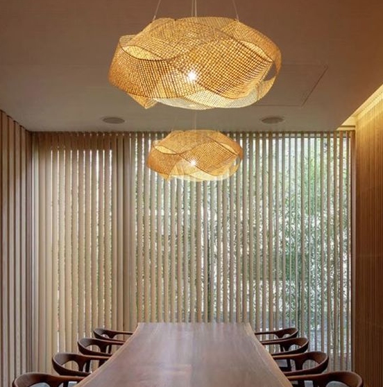 Two modern twisted bamboo lights placed over a dining table