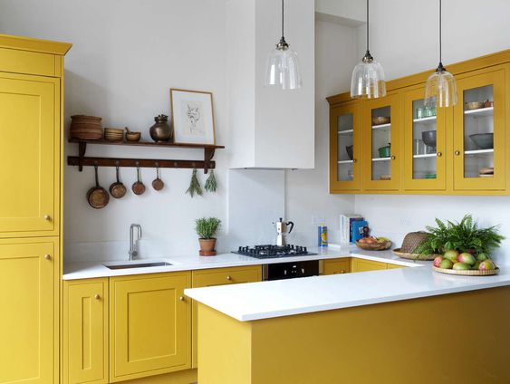 Small kitchen furniture design latest with bright yellow cabinets and a white countertop.