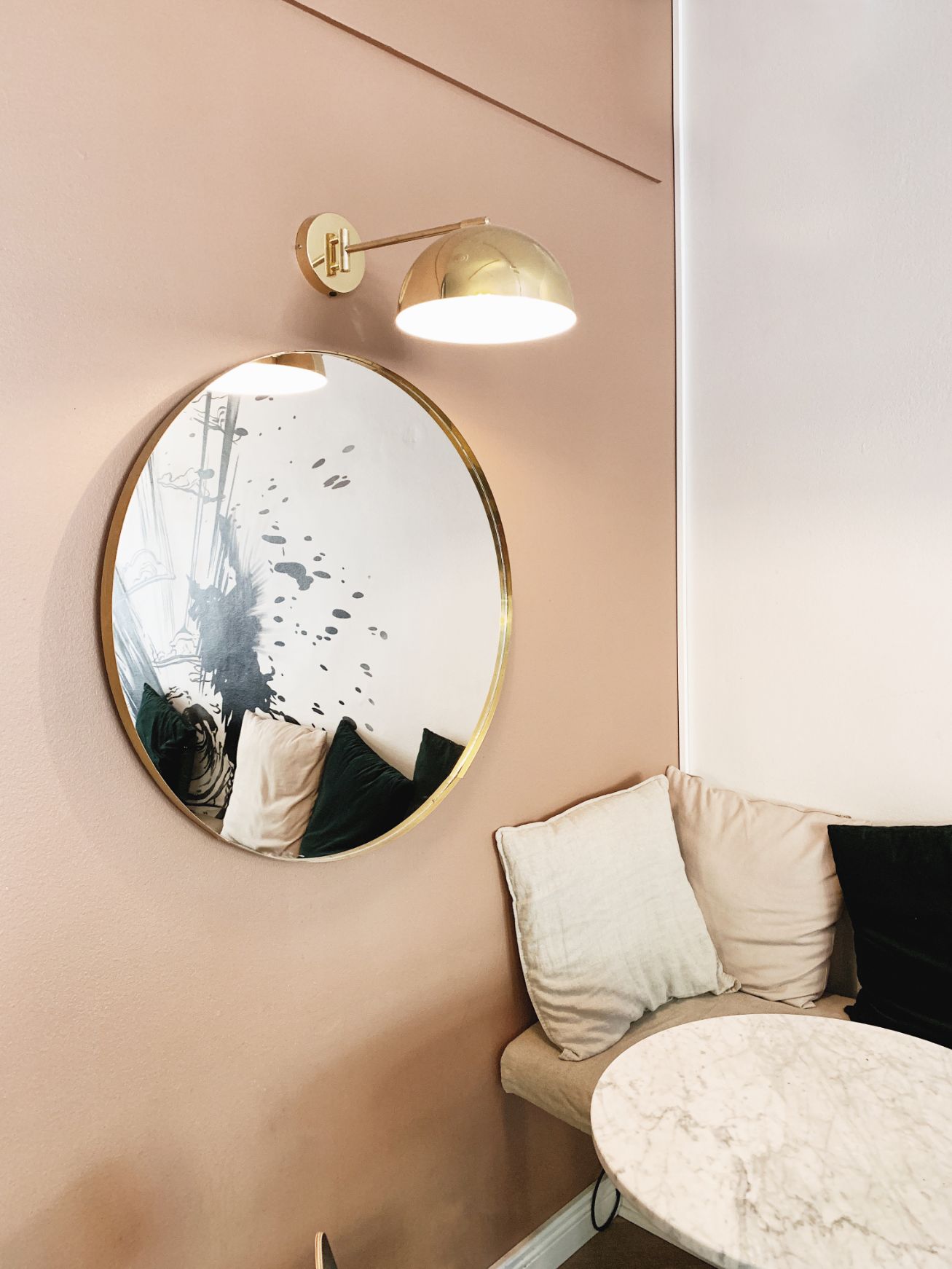 Round wall light above a circular mirror