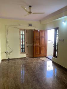 The room has a marble floor, wooden door, and ceiling fan