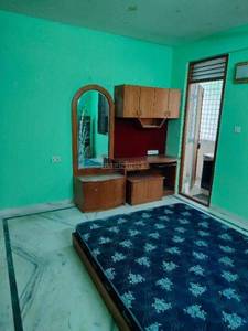 The bedroom has a bed, desk, mirror, and wardrobe at Sri Nanjundeshwara Residency, RR Nagar, Bangalore