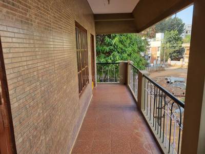 The brick wall features a door, window, and balcony railing