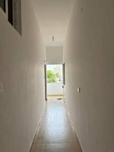 The hallway features a tiled floor, light fixture, and wallmounted switch
