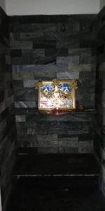 The religious shrine contains a framed picture and offerings