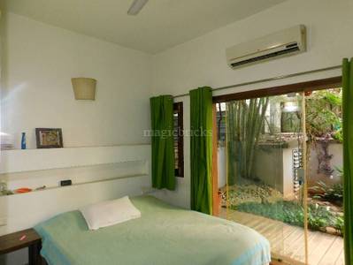 The bedroom has air conditioning, a bed, nightstand, shelves, and sliding glass door at Milford Terrace Apartments, Block 3rd Koramangala, Bangalore
