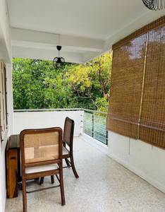 The balcony has furniture and greenery outside