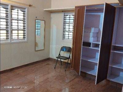 The room features wooden flooring, windows, a chair, and a wardrobe
