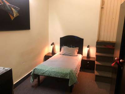 The bedroom contains a bed, lamps, painting, and stairs